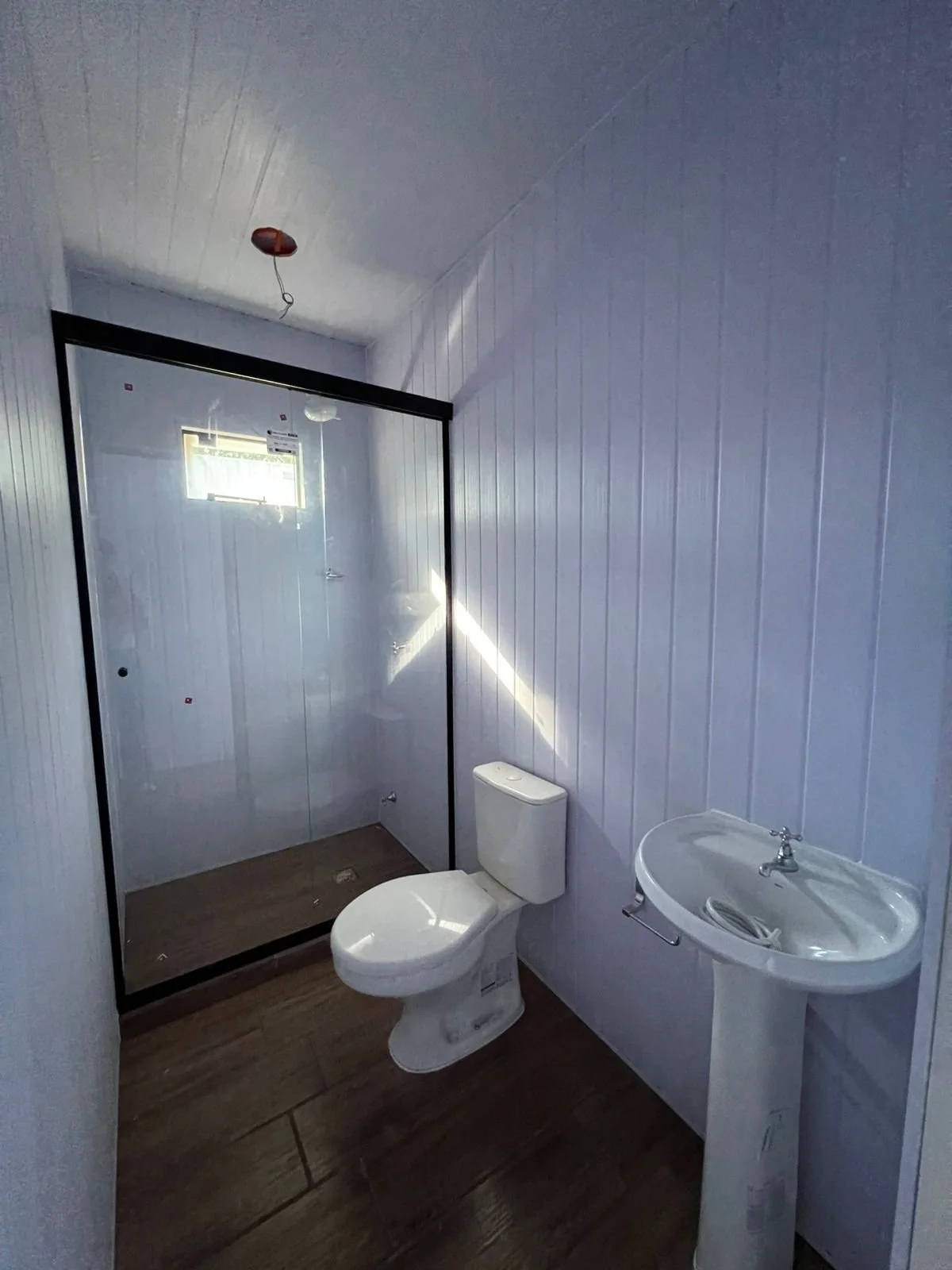 Baño en contenedor con mampara blindex